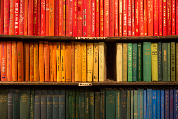 A bookshelf containing books ordered by colour